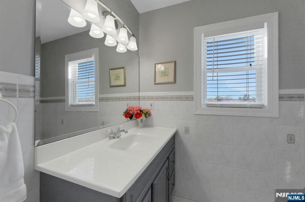 19 Hamilton Avenue Kearny, NJ 07032 - Photo 19 of 33 a bathroom with a sink a vanity and a mirror