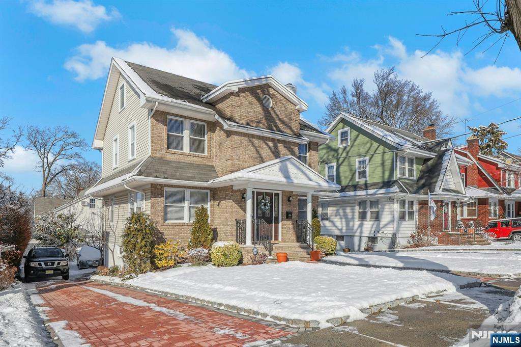 19 Hamilton Avenue Kearny, NJ 07032 - Photo 2 of 33 a view of a white house with large windows and a table and chairs under an umbrella