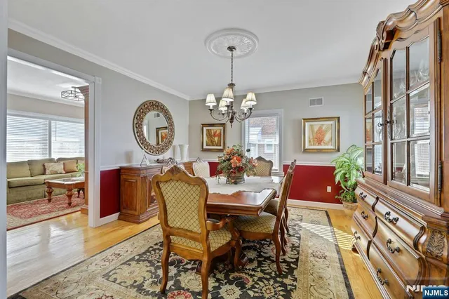 a kitchen with stainless steel appliances granite countertop a refrigerator a stove a sink a dining table and chairs