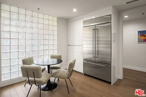 a kitchen with a refrigerator and wooden cabinets