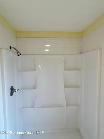 a white toilet sitting next to a white wall
