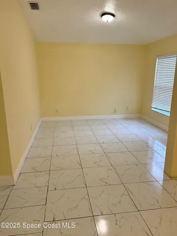 a view of a livingroom with an empty space and a window