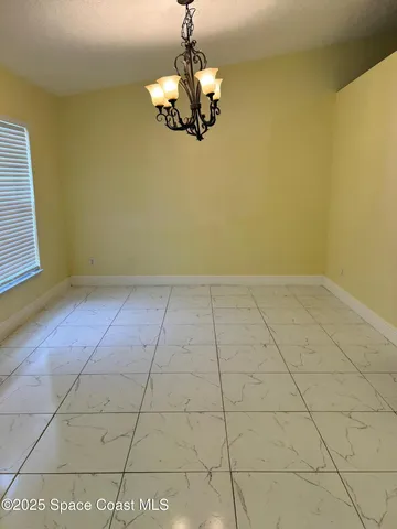a view of a room with a chandelier fan and windows