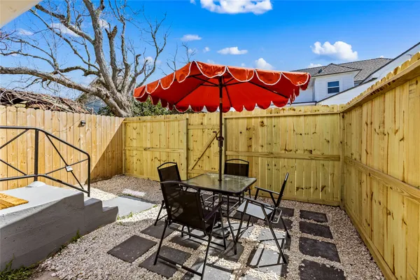 a view of a patio with table and chairs with wooden floor and fence