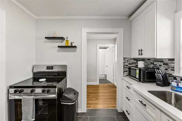 a kitchen with a stove and white cabinets
