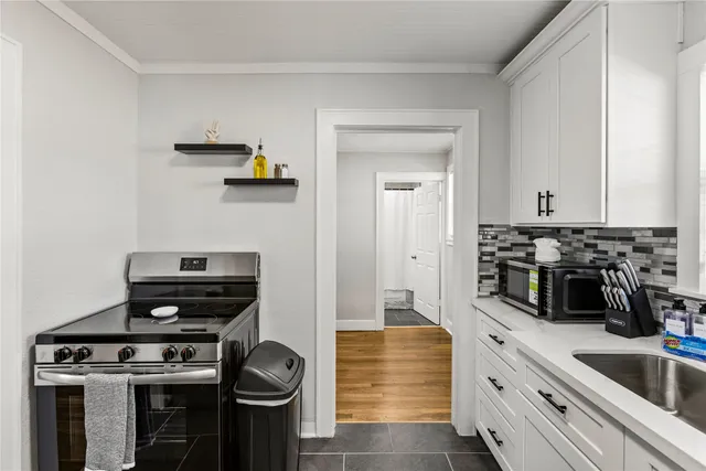 a kitchen with a stove and white cabinets