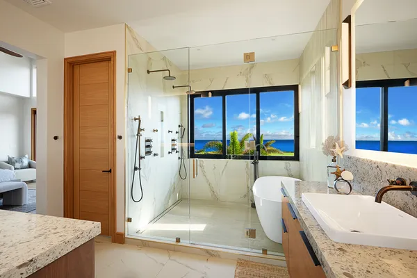 a spacious bathroom with a granite countertop tub sink a mirror and shower