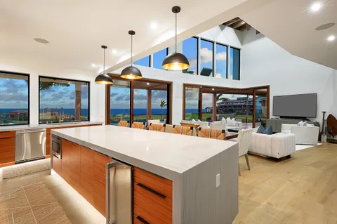a view of living room kitchen with stainless steel appliances and chandelier