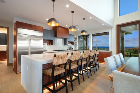 a dining table with chairs and kitchen view