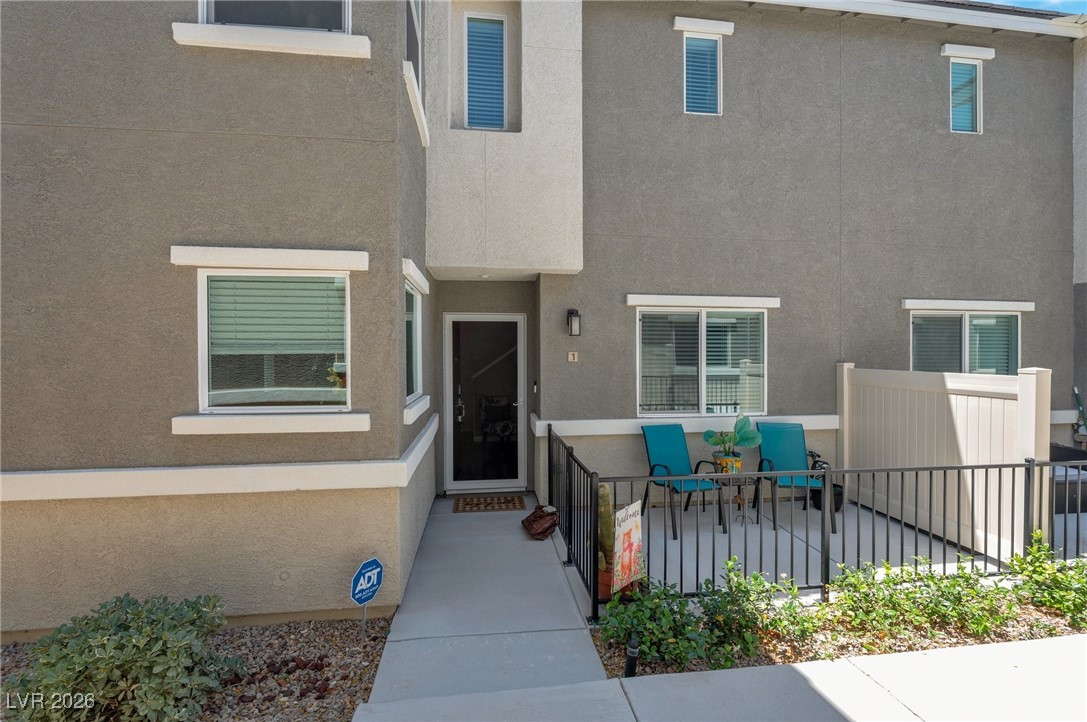 Doorway to property featuring stucco siding and a patio area