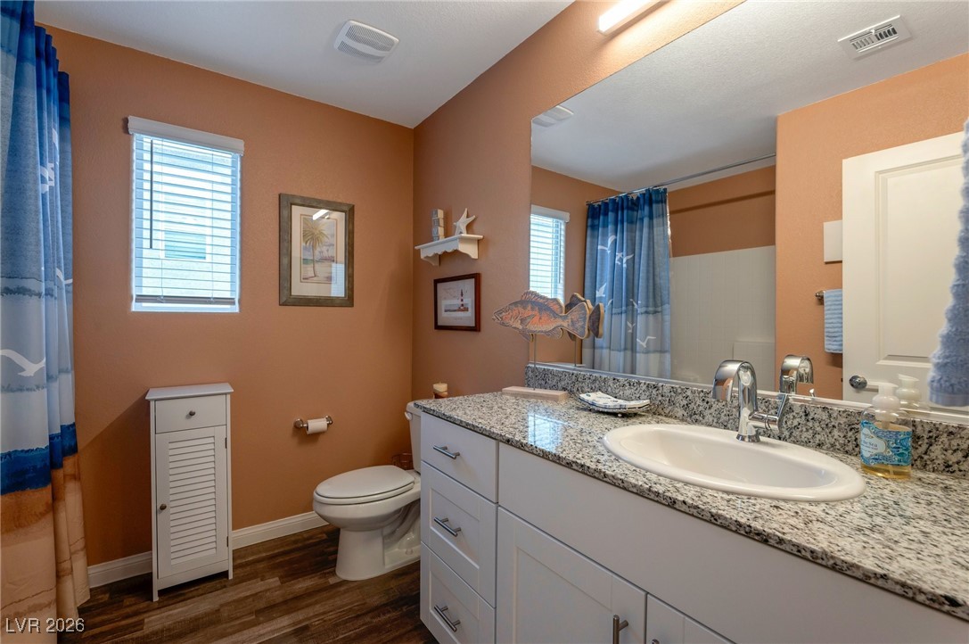 12348 Golden Wreath Road, Unit 1 Las Vegas, NV 89183 - Photo 23 of 37 Full bath with vanity, dark wood-style floors, and curtained shower