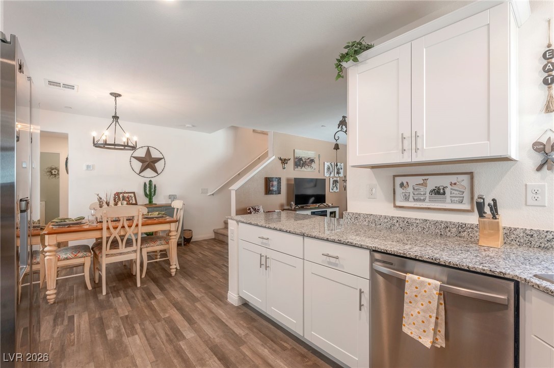 12348 Golden Wreath Road, Unit 1 Las Vegas, NV 89183 - Photo 6 of 37 Kitchen featuring appliances with stainless steel finishes, white cabinets, pendant lighting, and light stone counters