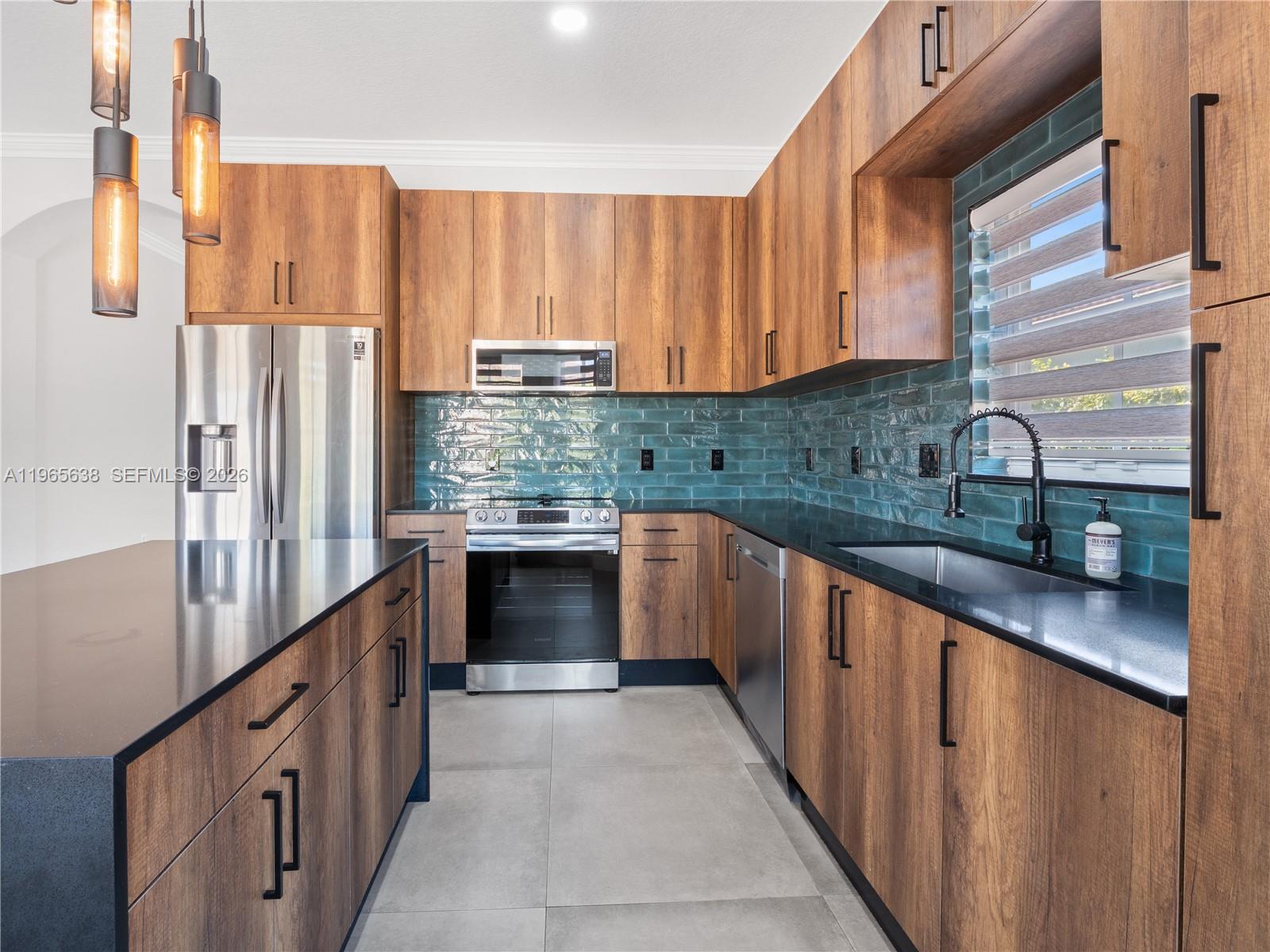 14833 Southwest 35th Lane Miami, FL 33185 - Photo 22 of 45 a kitchen with stainless steel appliances granite countertop a stove a sink and a refrigerator