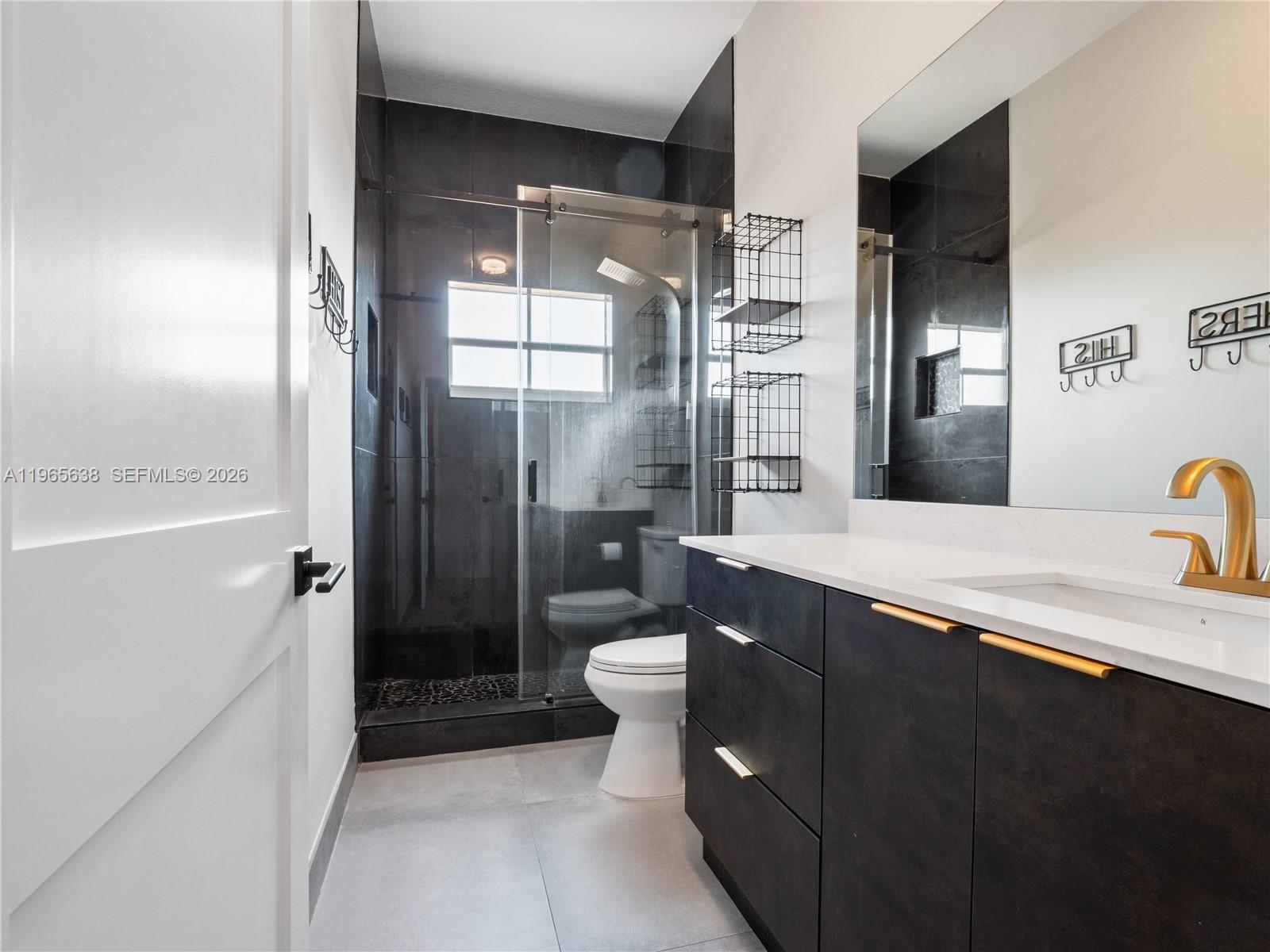 14833 Southwest 35th Lane Miami, FL 33185 - Photo 31 of 45 a bathroom with a double vanity sink toilet and shower