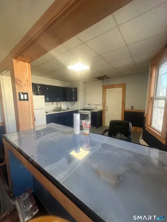 a room with kitchen island granite countertop a sink stove and refrigerator