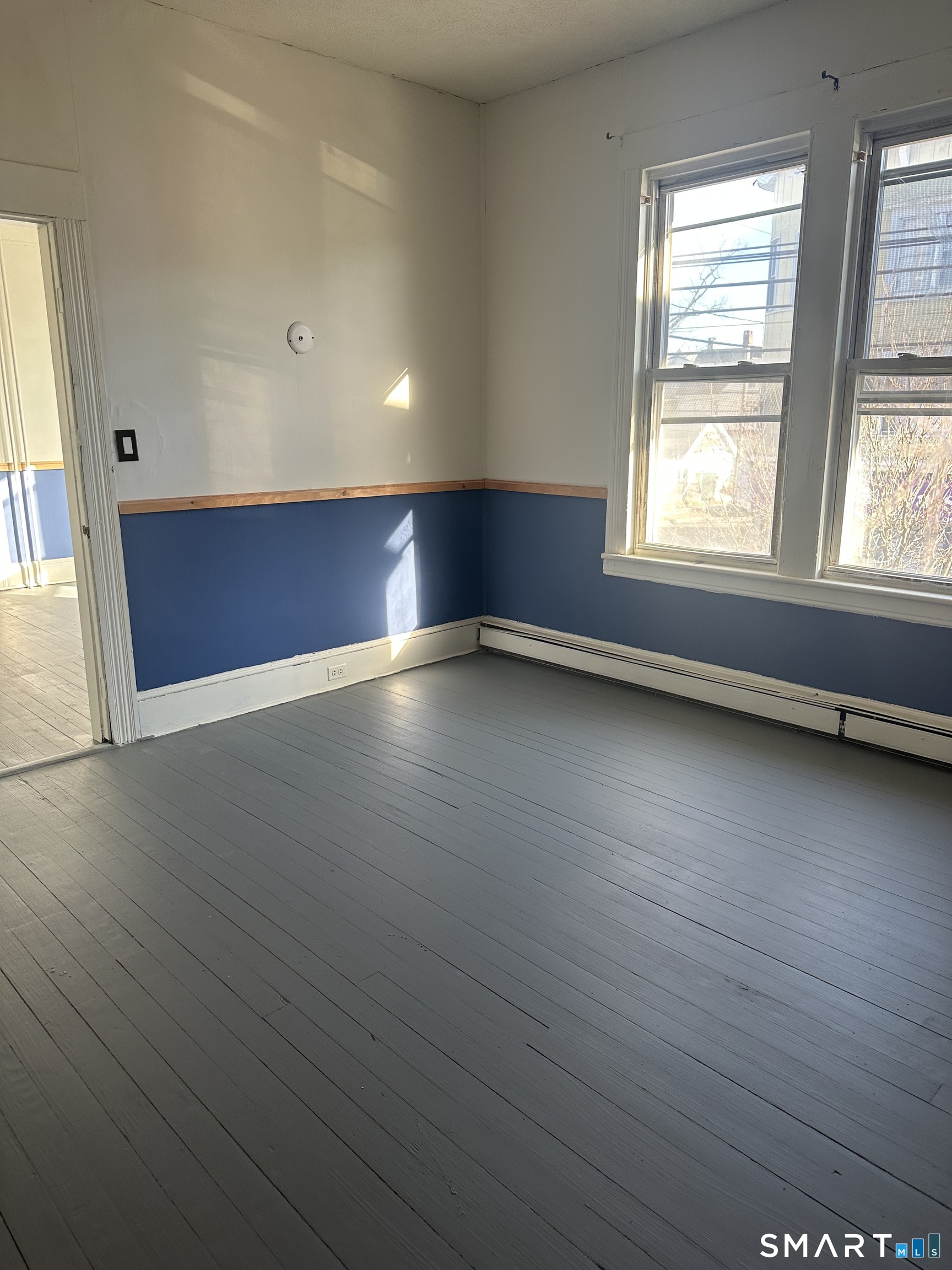 1365 East Main Street Bridgeport, CT 06608 - Photo 18 of 40 an empty room with wooden floor and windows