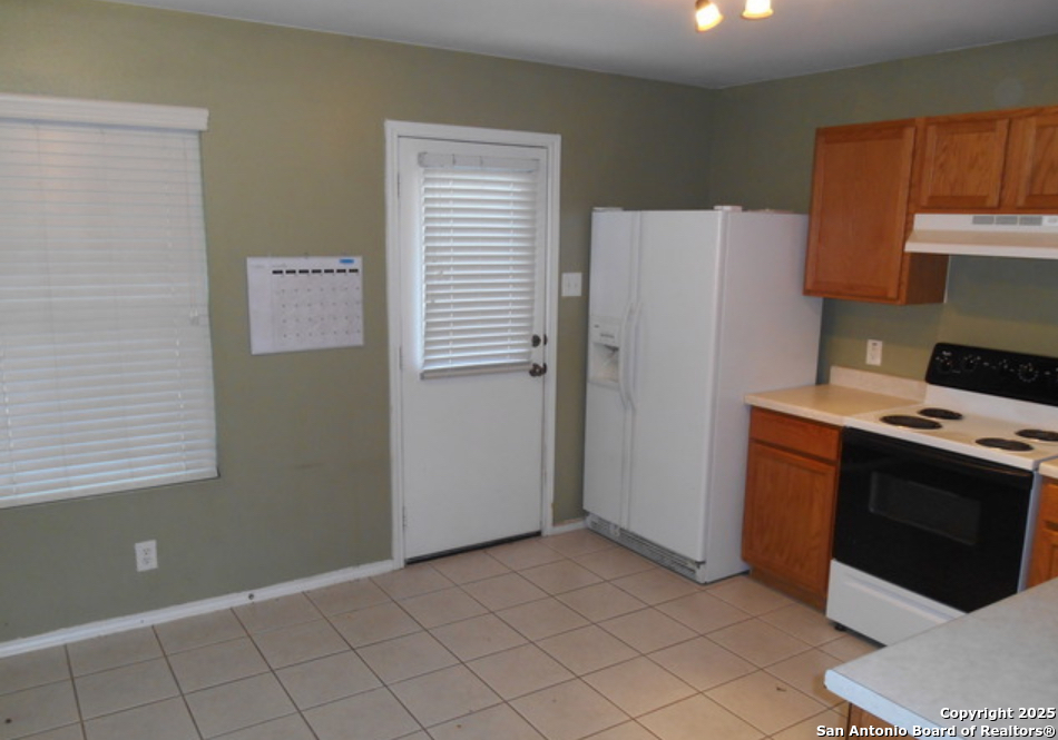 8011 Rio NIEBLA San Antonio, TX 78249 - Photo 6 of 18 a kitchen with a stove and a refrigerator