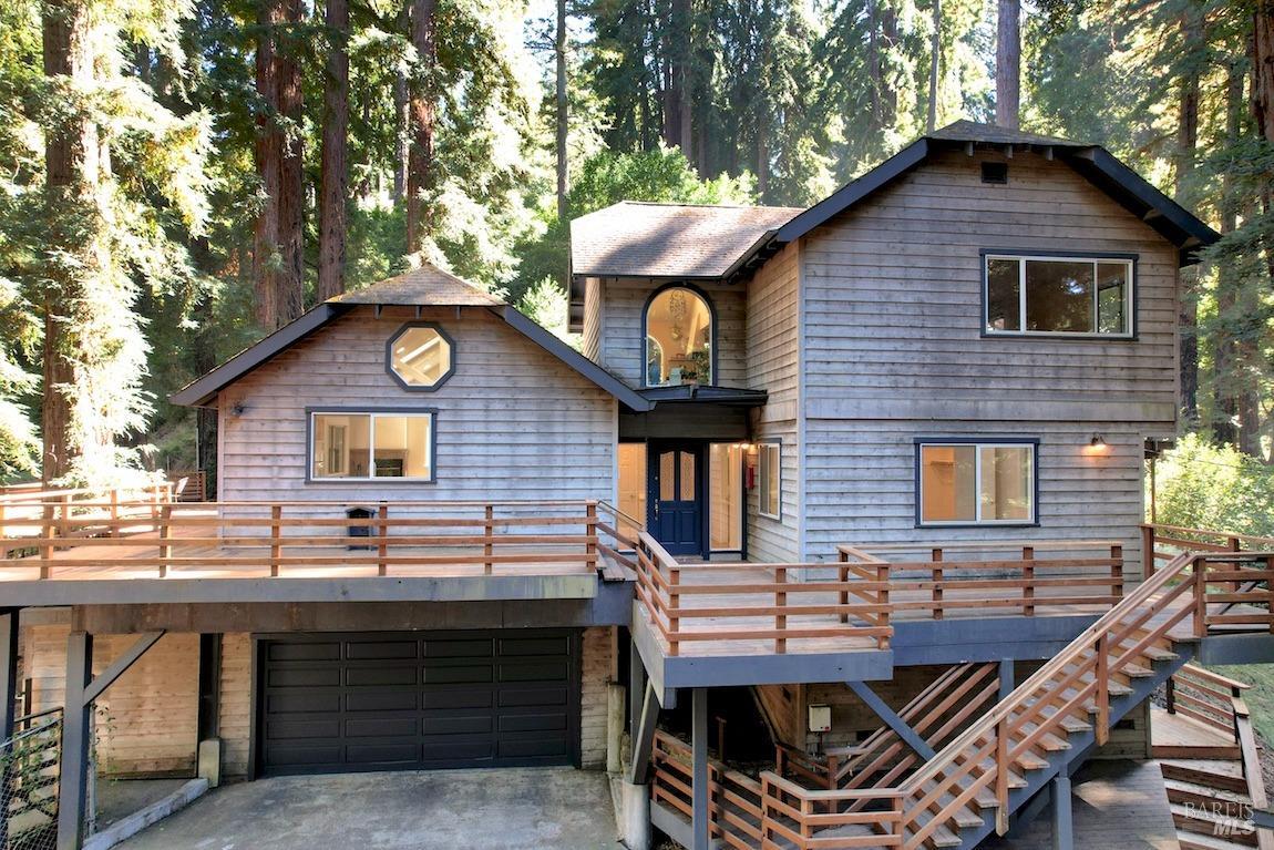 a view of a house with a small yard and a large tree