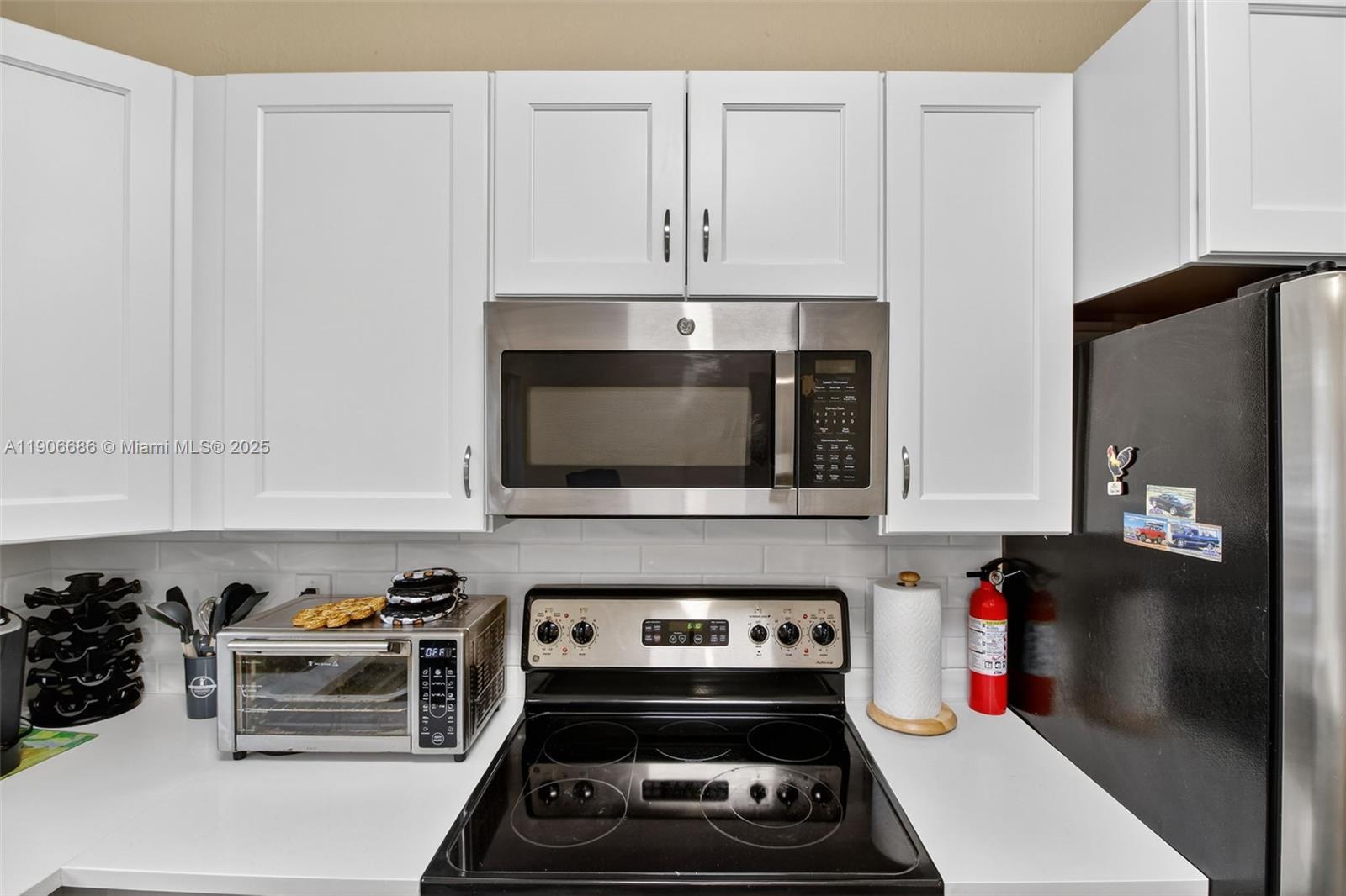 5302 Southwest 164th Place Miami, FL 33185 - Photo 15 of 43 a kitchen with microwave a stove and cabinets
