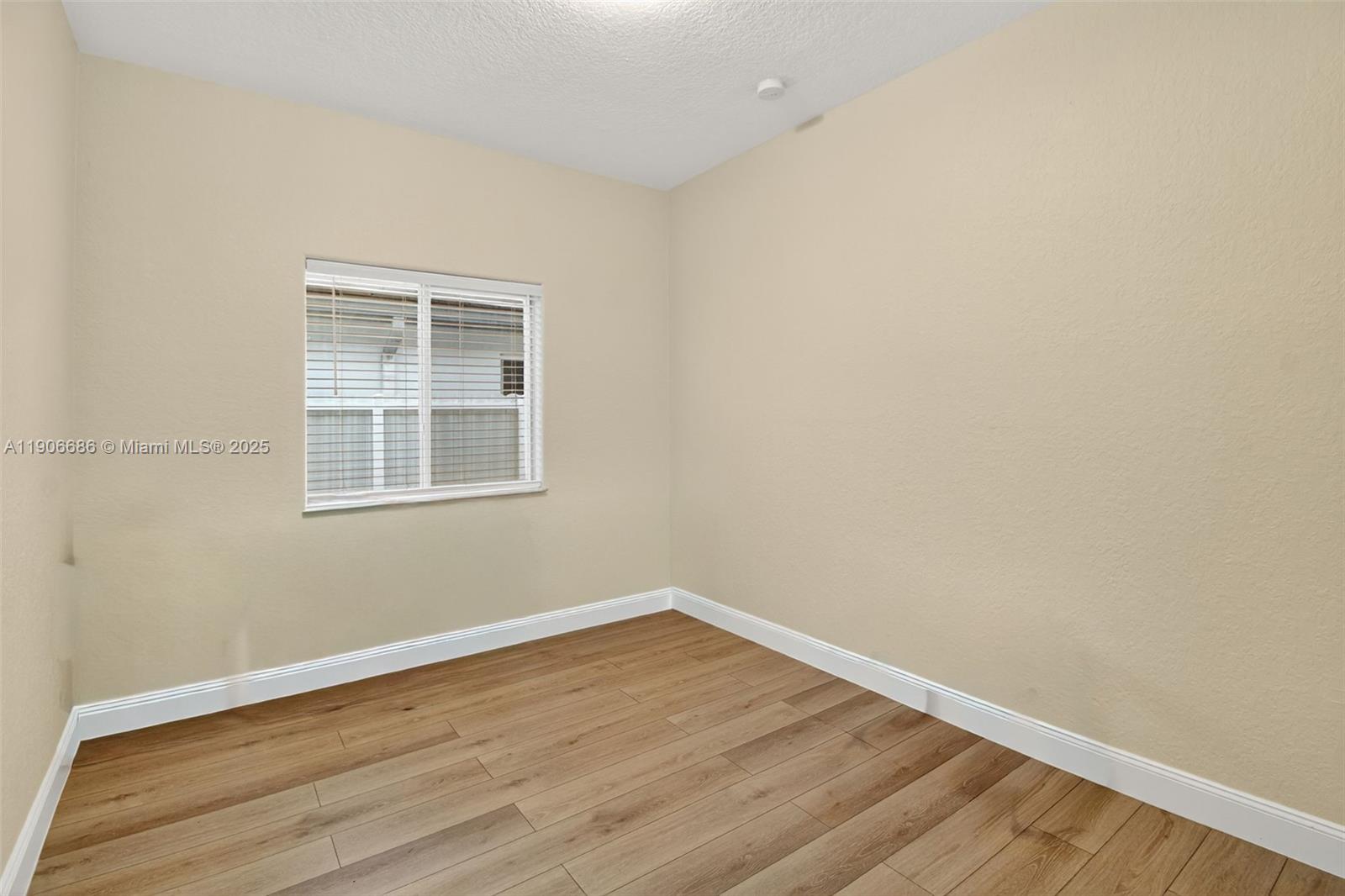 5302 Southwest 164th Place Miami, FL 33185 - Photo 23 of 43 an empty room with wooden floor and windows