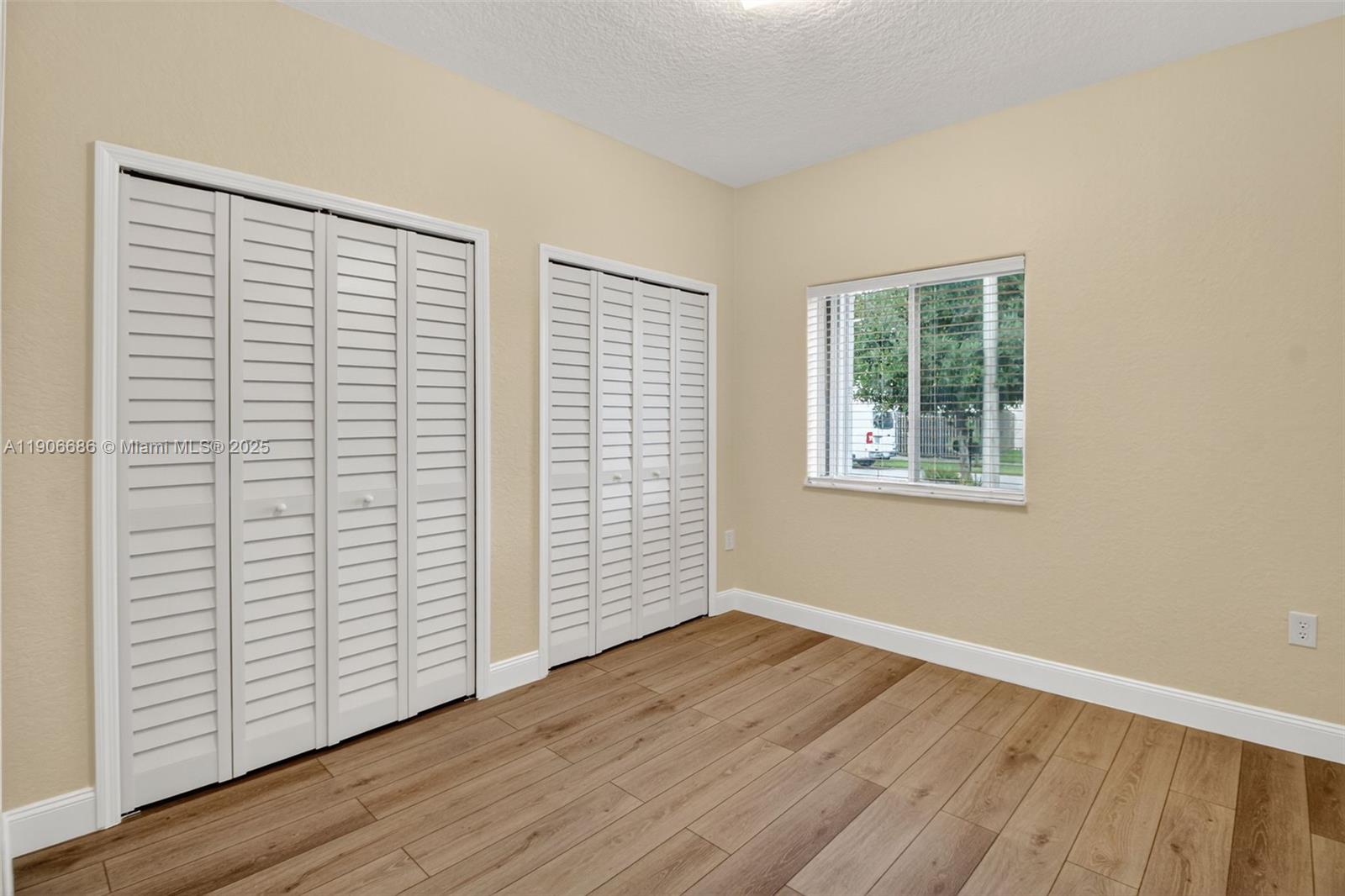 5302 Southwest 164th Place Miami, FL 33185 - Photo 26 of 43 an empty room with wooden floor and windows