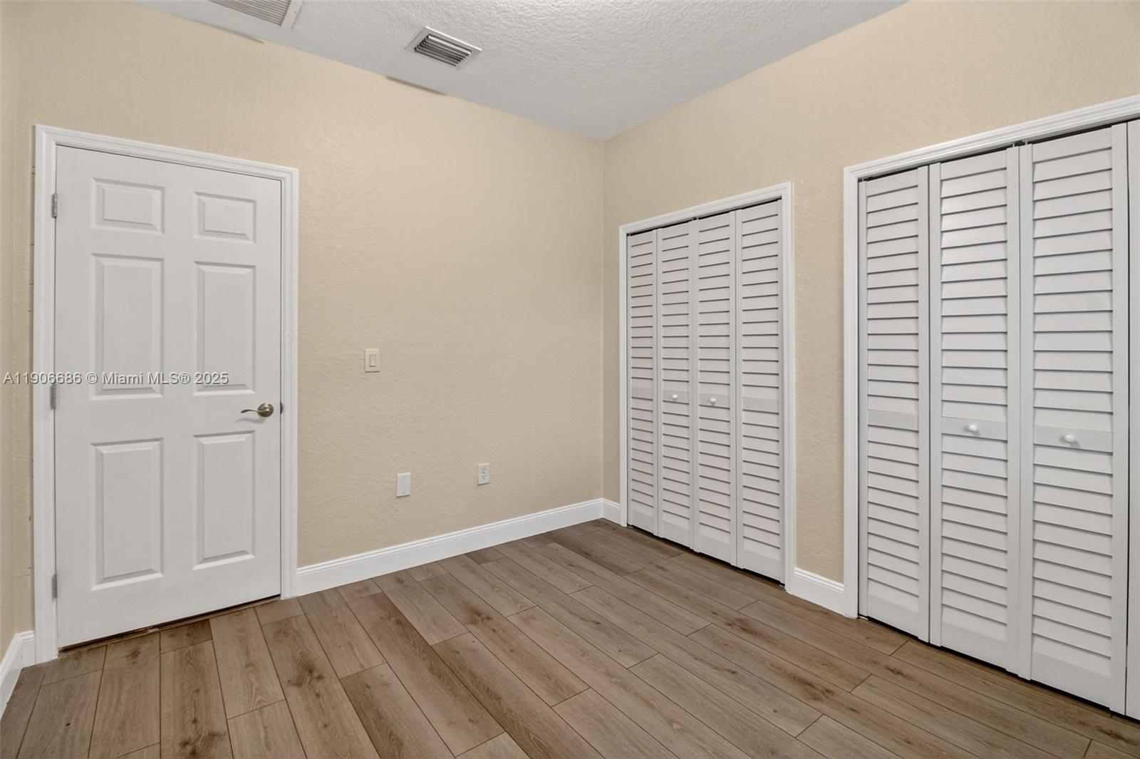 5302 Southwest 164th Place Miami, FL 33185 - Photo 28 of 43 an empty room with wooden floor and windows