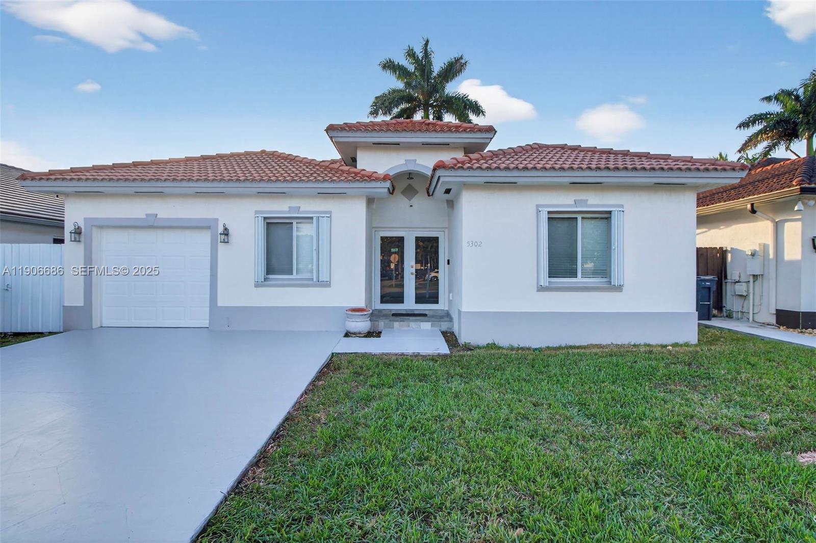 5302 Southwest 164th Place Miami, FL 33185 - Photo 3 of 43 a front view of a house with a yard and garage