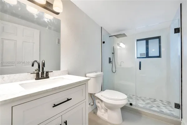 a bathroom with a sink a toilet and shower
