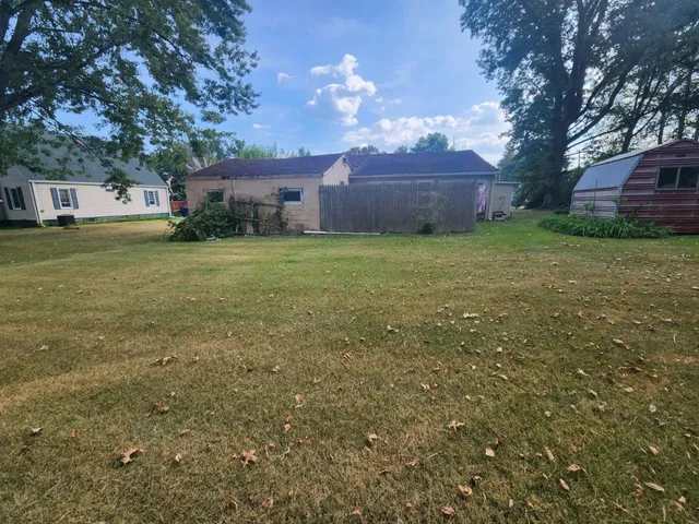 a front view of house with yard and trees in the background