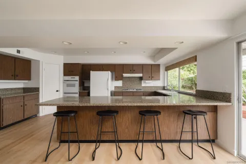 a kitchen with kitchen island granite countertop a sink and cabinets