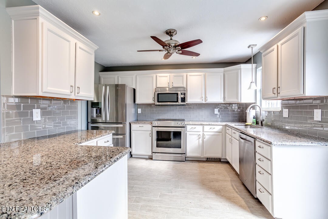 1296 Emerald Forest Lane Powell, TN 37849 - Photo 16 of 43 a kitchen with granite countertop a stove sink and microwave
