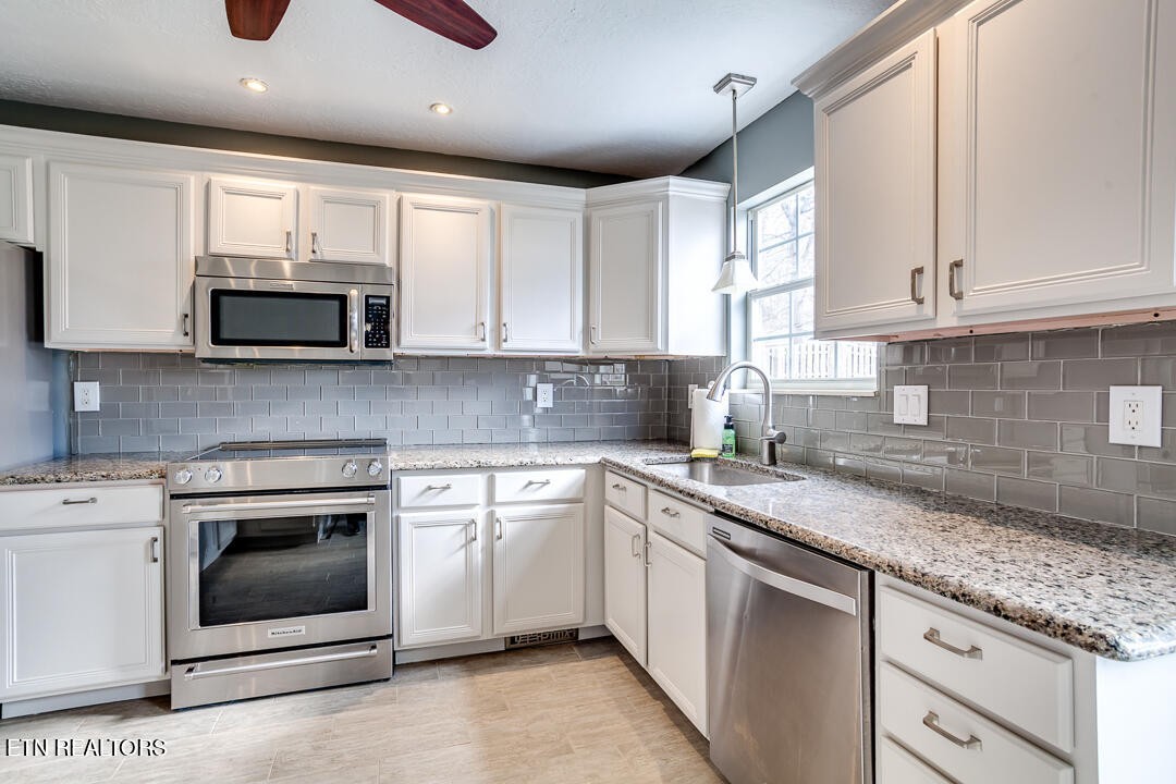 1296 Emerald Forest Lane Powell, TN 37849 - Photo 17 of 43 a kitchen with granite countertop a stove sink and cabinets