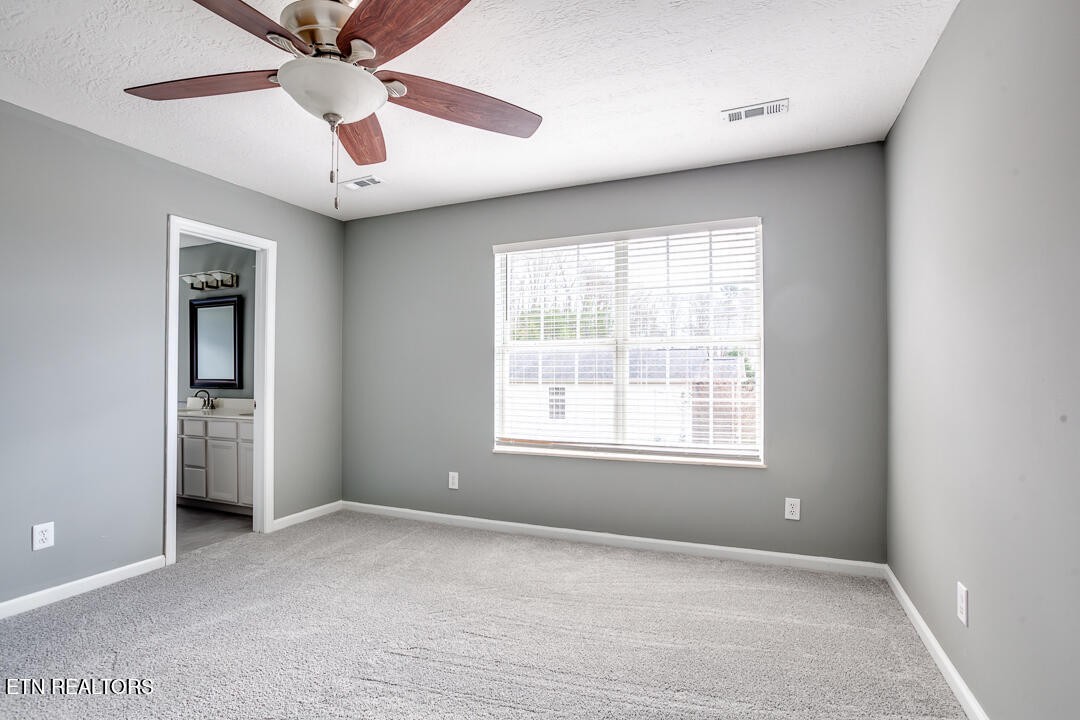 1296 Emerald Forest Lane Powell, TN 37849 - Photo 24 of 43 an empty room with chandelier fan and windows