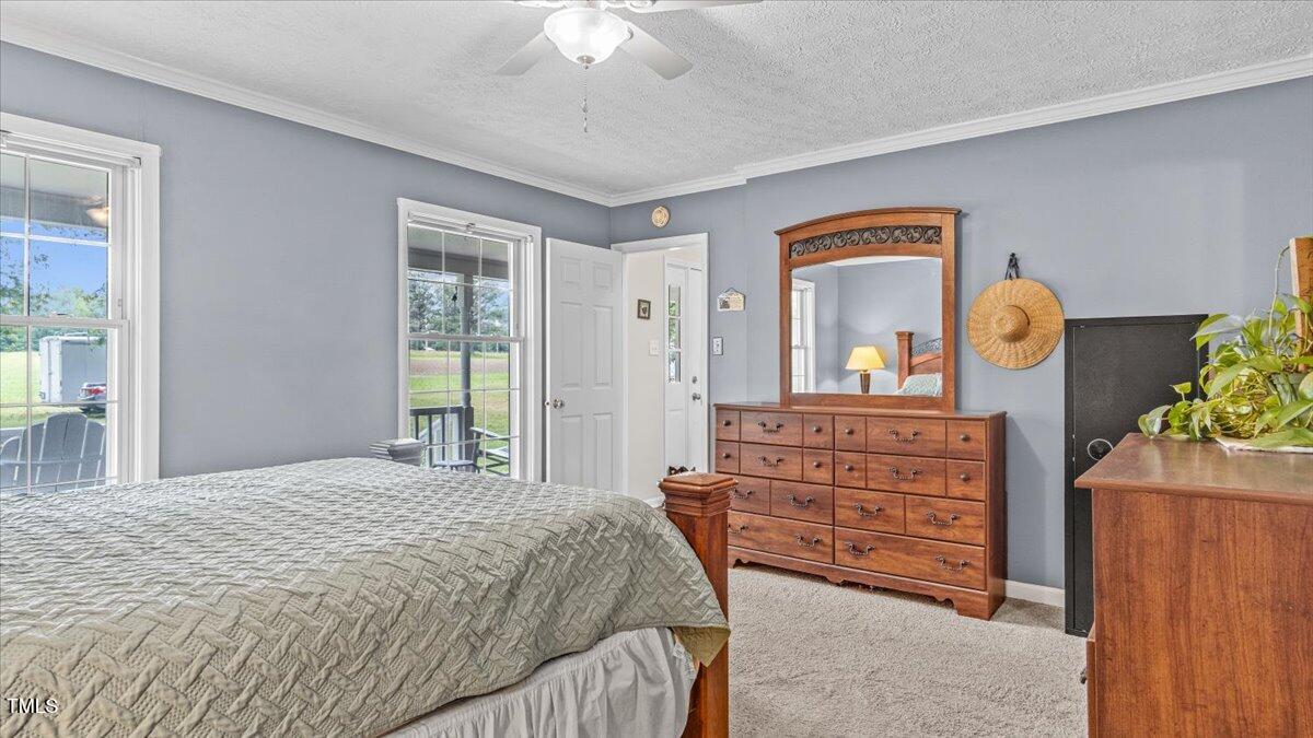 1401 Berea Road Rougemont, NC 27572 - Photo 23 of 65 a bedroom with a bed a chandelier and dresser