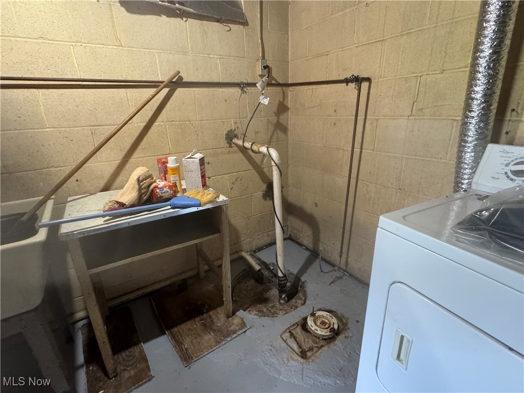 25911 Tryon Road Bedford, OH 44146 - Photo 26 of 49 Clothes washing area featuring washer / clothes dryer and concrete block wall and sump pump