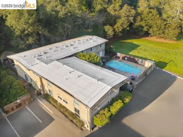 an aerial view of a house with a yard swimming pool and outdoor seating