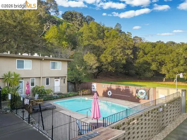 a view of a swimming pool with a patio and a yard