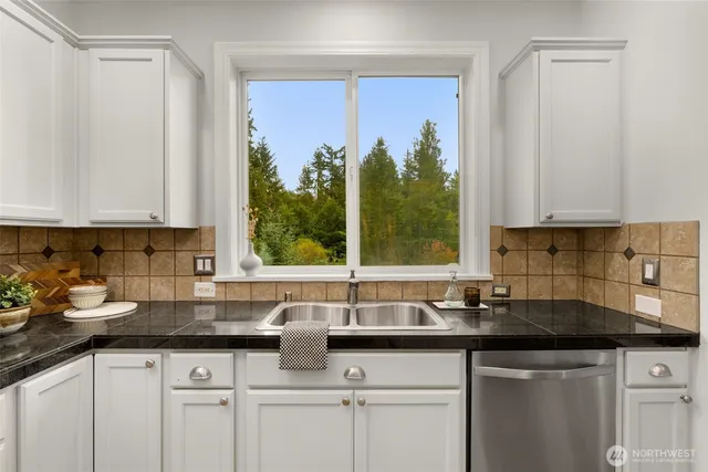 a kitchen with stainless steel appliances granite countertop a sink a cabinets and a window