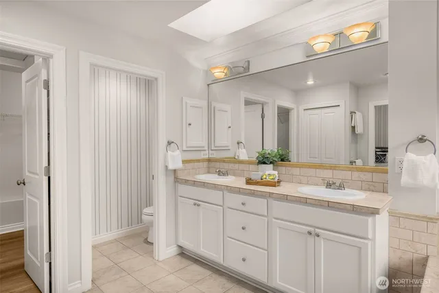 a bathroom with a granite countertop sink a large mirror and shower