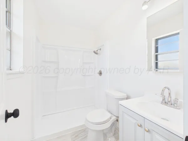 a bathroom with a sink a toilet and shower