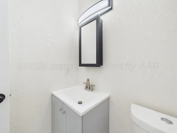 a bathroom with a toilet a sink and mirror