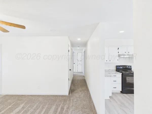 a view of a kitchen with refrigerator and white cabinets