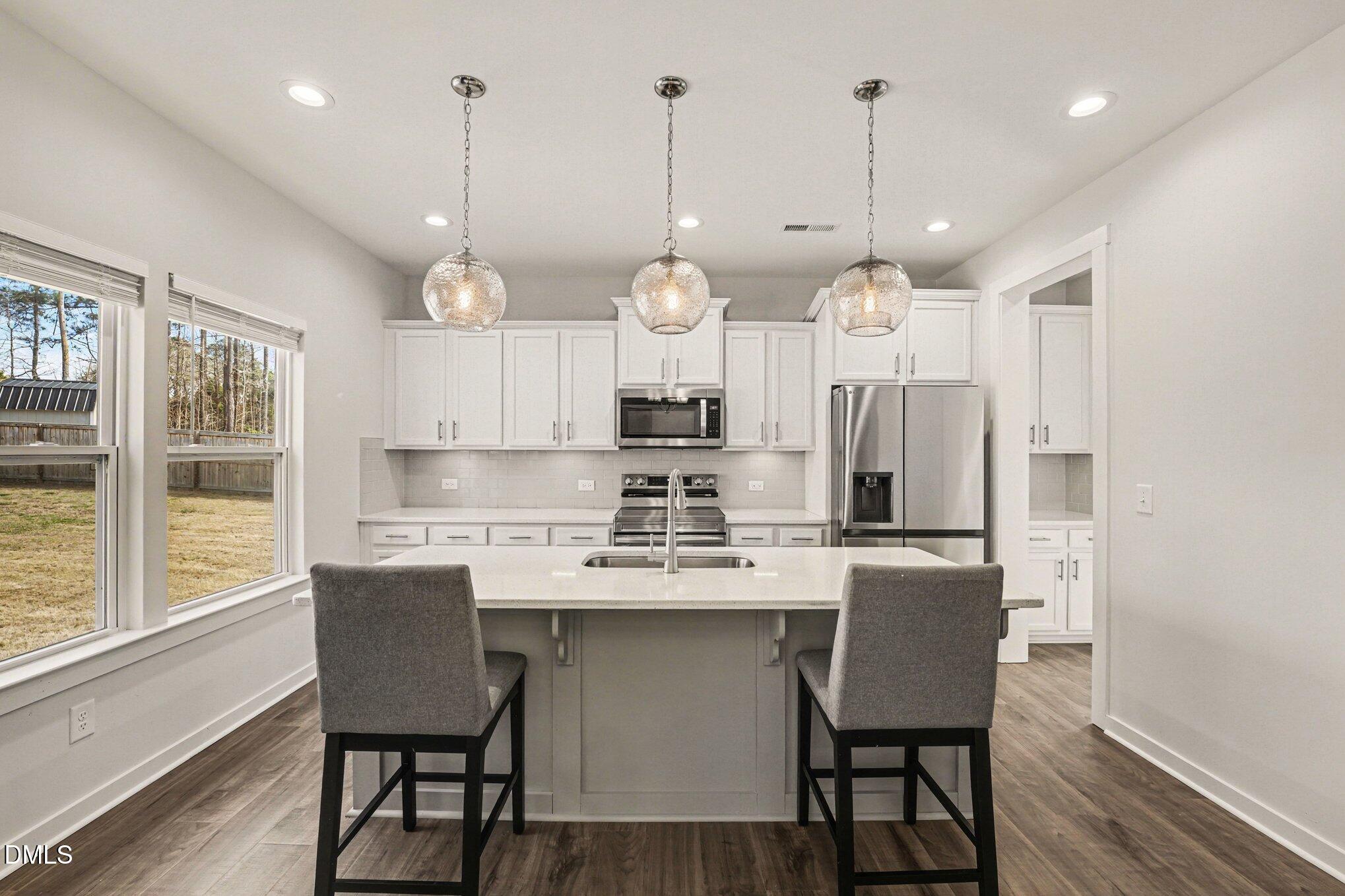 51 East Dentaires Way Willow Spring, NC 27592 - Photo 13 of 39 a kitchen with a dining table chairs a refrigerator and cabinets