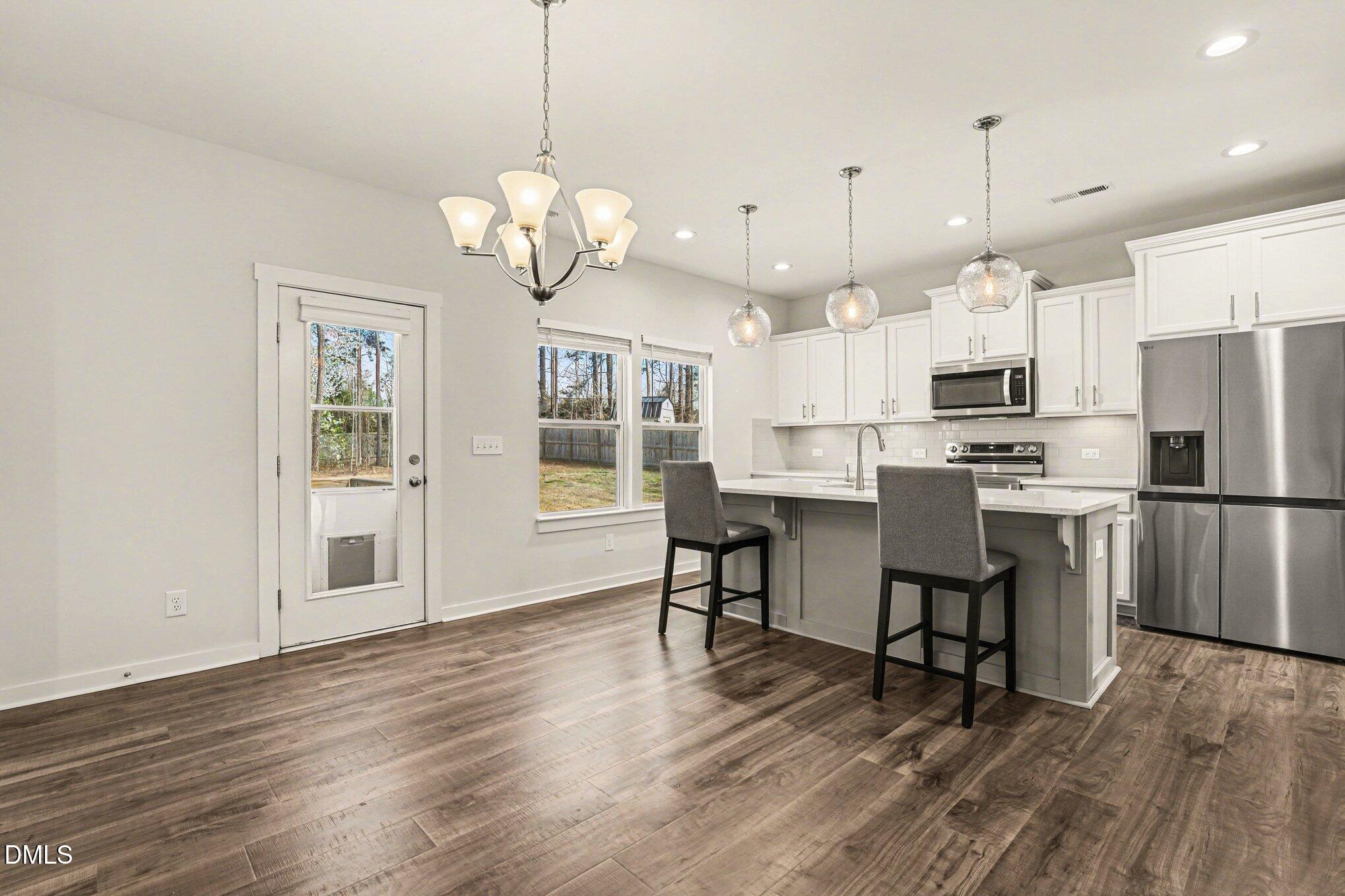 51 East Dentaires Way Willow Spring, NC 27592 - Photo 14 of 39 a view of kitchen with refrigerator microwave and wooden floor