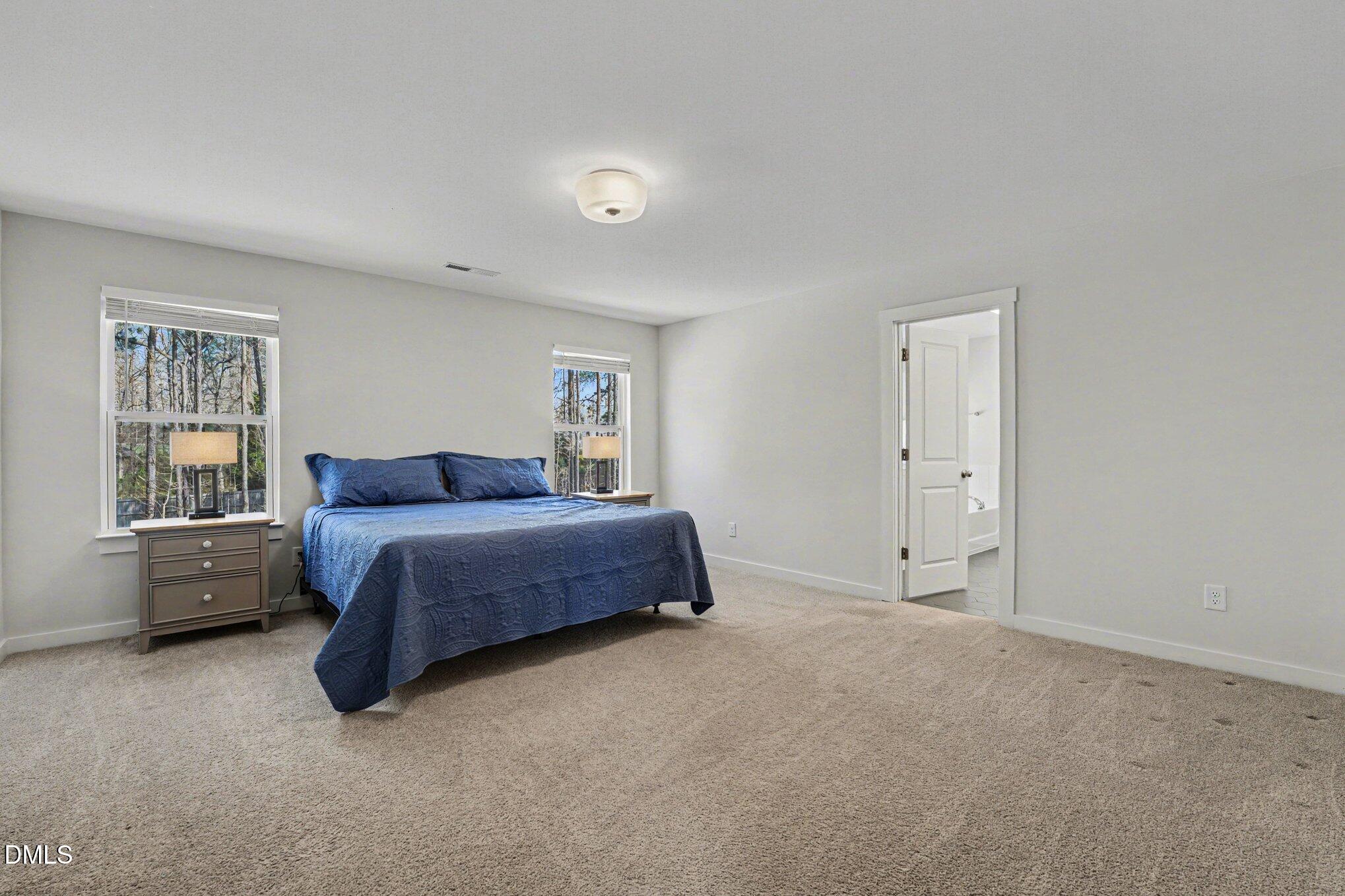 51 East Dentaires Way Willow Spring, NC 27592 - Photo 24 of 39 a spacious bedroom with a bed and a cabinets