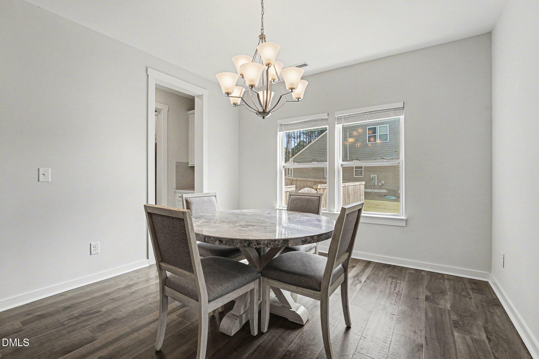 51 East Dentaires Way Willow Spring, NC 27592 - Photo 9 of 39 a view of a dining room with furniture a chandelier and wooden floor
