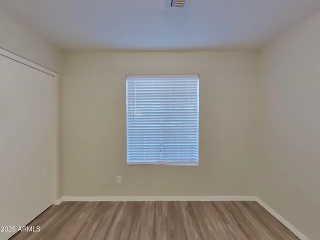 a view of a small space with wooden floor and a window