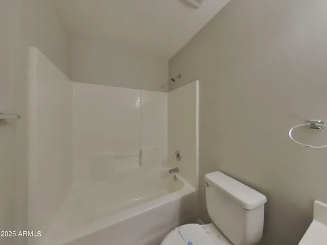 a white toilet sitting next to a bath tub