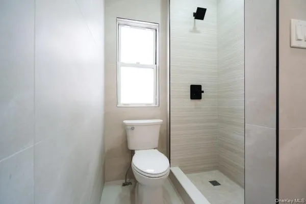 a bathroom with a toilet and a shower