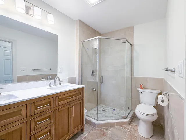 a bathroom with a granite countertop sink toilet and shower